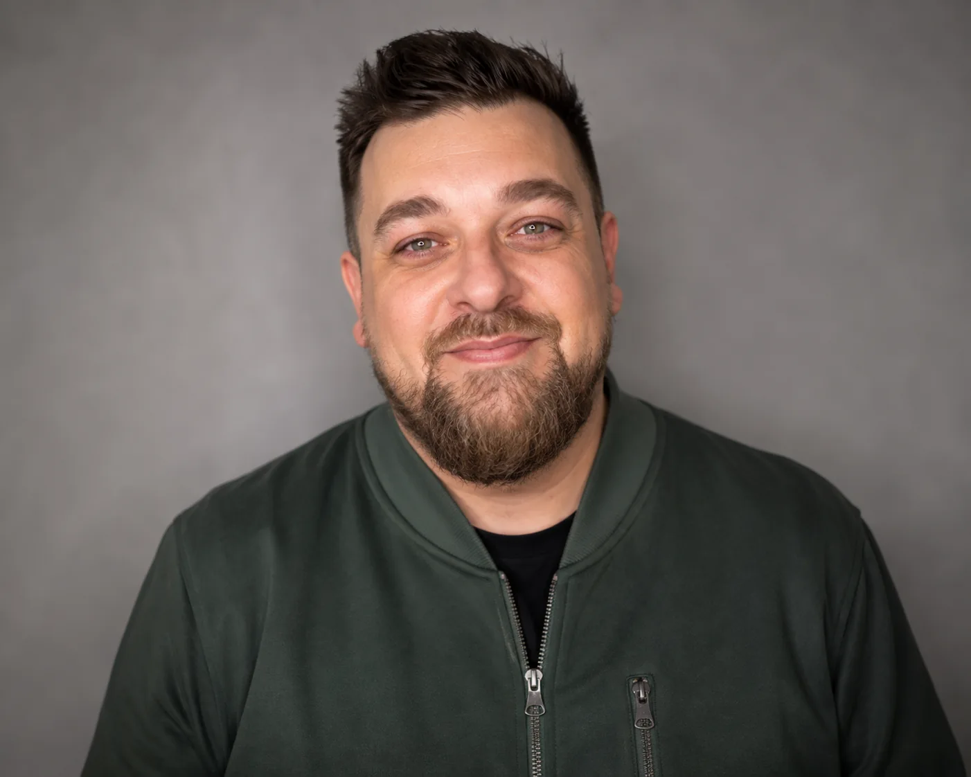 Dan Galea smiling in a green jacket