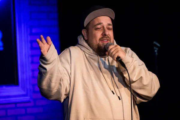 Dan gesturing with one hand while holding a microphone.